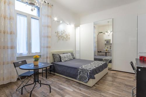 um quarto com uma cama e uma mesa num quarto em Lovely flat - Orti 16 em Milão