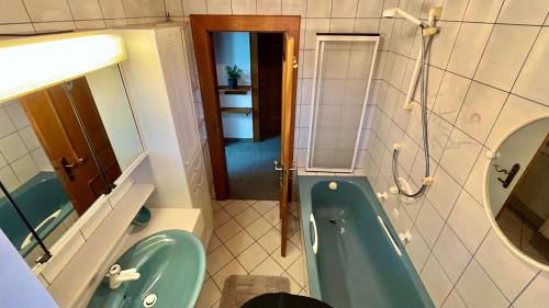 a bathroom with a blue tub and a sink at Maple Appartement in Mayrhofen