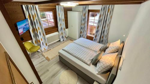 Dormitorio pequeño con cama y TV en Maple Appartement, en Mayrhofen