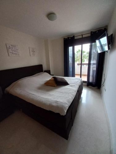 Schlafzimmer mit einem großen Bett und einem Fenster in der Unterkunft Nice apartment within walking distance to the center in La Cala de Mijas