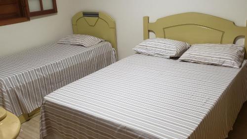 two beds sitting next to each other in a room at Sítio Alazão in Moeda