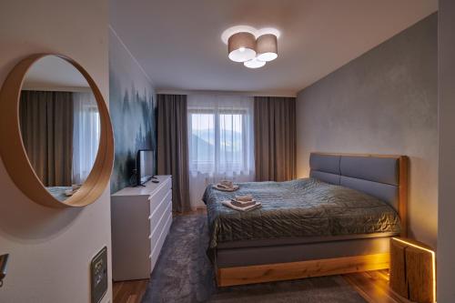 una camera con letto e specchio di Donnovall Apartment a Donovaly