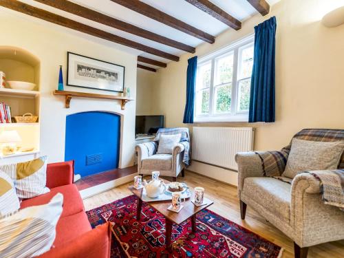 a living room with two chairs and a fireplace at Cosy 2 bedroom Victorian Cottage - Pass the Keys in Ludlow