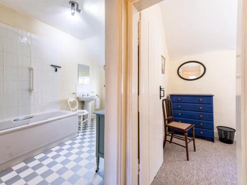 a bathroom with a tub and a sink and a chair at Cosy 2 bedroom Victorian Cottage - Pass the Keys in Ludlow