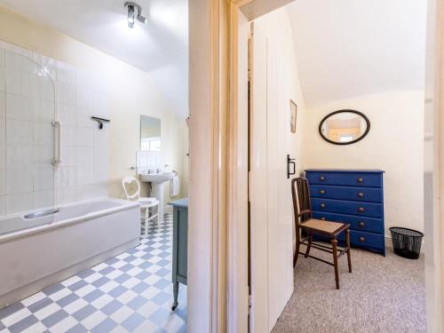 a bathroom with a tub and a sink and a chair at Pass the Keys Cosy 2 bedroom Victorian Cottage in Ludlow