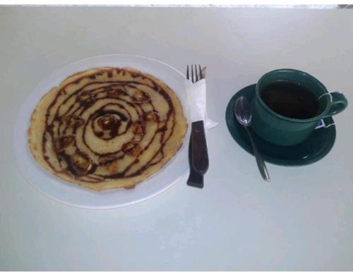 een bord met een gebakje en een kopje koffie bij ADELYA HOMESTAY in Praya