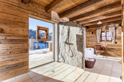 eine große Glastür in einem Zimmer mit Holzwänden in der Unterkunft Schrofen Chalets in Jungholz