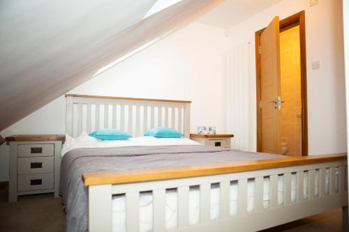 a bedroom with a white bed with blue pillows at 2 Double bedroom House in Harrow