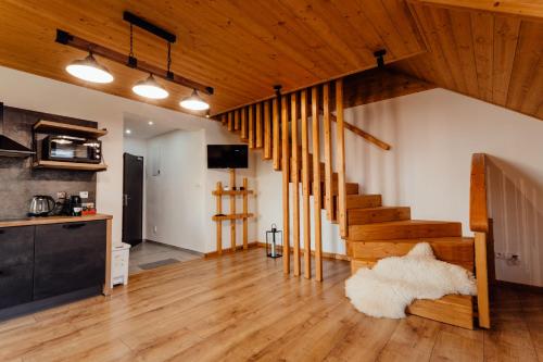 a living room with wooden floors and a staircase at Miracle Seasons in Liptovský Mikuláš