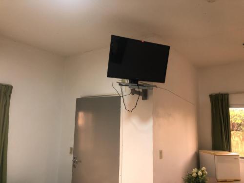 a flat screen tv on the ceiling of a room at Hotel Bar Restaurant Emergency 911 STO LK GROUP in Paramaribo