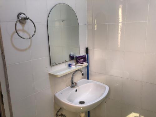 a white bathroom with a sink and a mirror at Hotel Bar Restaurant Emergency 911 STO LK GROUP in Paramaribo