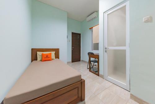um quarto com uma cama com uma almofada laranja em KoolKost @ The Casa 18 (minimum stay 30 nights) em Bandung