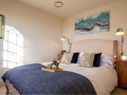 een slaapkamer met een bed met een blauw dekbed bij Rose Cottage, Rodborough in Stroud