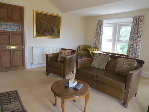 a living room with two chairs and a couch and a table at The Vicarage Apartment in Hunstanton