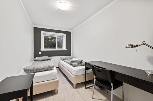 een woonkamer met een tafel, een bank en een bureau bij Acco Guesthouse in Akureyri