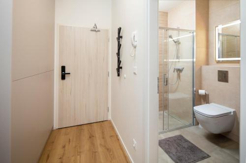 a bathroom with a toilet and a glass shower door at Apartmán Holia, Kubínska Hoľa in Dolný Kubín