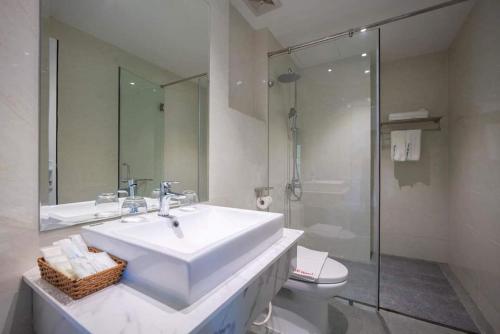 y baño con lavabo, ducha y aseo. en UM-PQ hotel Phú Quốc en Phu Quoc