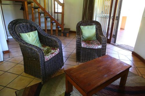 two chairs and a coffee table in a living room at Impangele Lodge in Muldersdrift