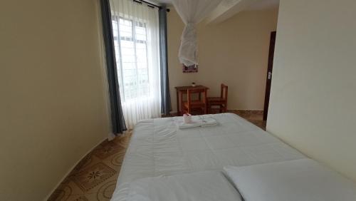 a bedroom with a bed and a window at Lago Resort - Best Views in Kisumu in Kisumu