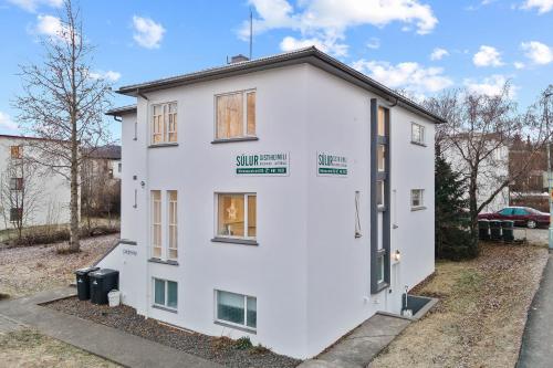 a white house with a window on the side of it at Acco Guesthouse in Akureyri