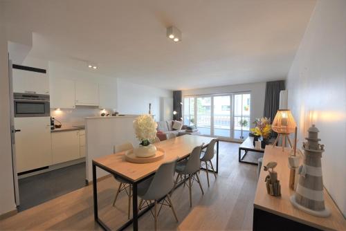een keuken en eetkamer met een tafel en stoelen bij Appartement spacieux à Knokke in Knokke-Heist
