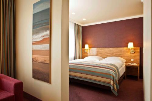 1 dormitorio con 1 cama y una pintura en la pared en Best Western Raphael Hotel Altona, en Hamburgo