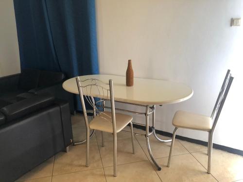 a table and chairs in a room with a couch at Hotel Bar Restaurant Emergency 911 STO LK GROUP in Paramaribo