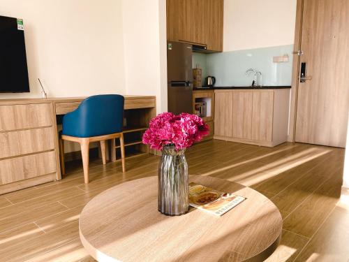 a vase filled with pink flowers sitting on a table at PH Hotel & Apartment in Hai Phong