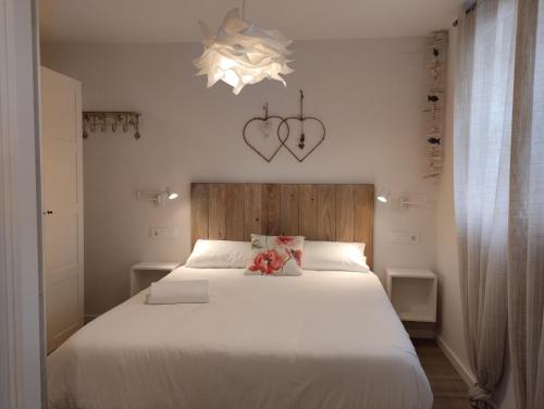 a bedroom with a large white bed with a teddy bear on it at Casas Natura Suites in Graus