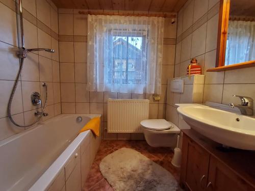 uma casa de banho com uma banheira, um lavatório e um WC. em Waschhütte, Ferienhaus em Finkenberg
