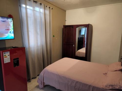 ラ・ガウレットにあるBackpackers rental room/bathroom onlyのベッドと薄型テレビのある寝室