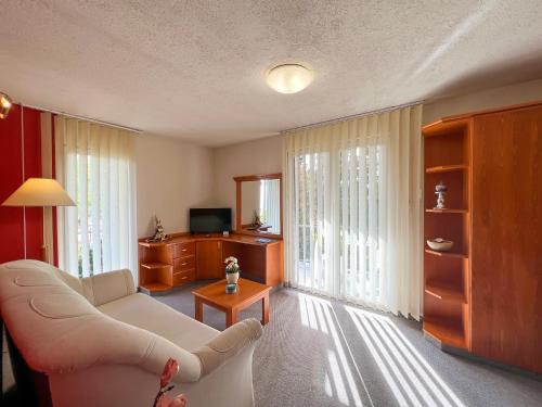 a living room with a white couch and a tv at Hévíz Apartman Hévíz in Hévíz