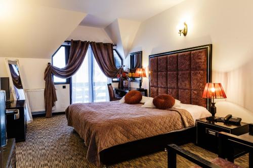 a bedroom with a large bed and a large window at CONTELE VLADIMIR in Bran