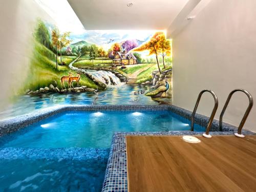 una piscina en una habitación con una pintura en la pared en Villa Krish, en Pondicherry