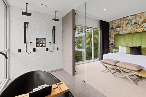 a bedroom with a large bed and a tub at Club Wyndham Airlie Beach in Airlie Beach
