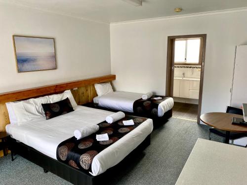 Habitación de hotel con 2 camas y mesa en Motel Stawell, en Stawell