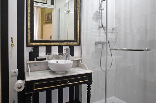 a bathroom with a sink and a shower with a mirror at Les Chambres de Mathilde in Angers