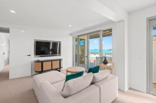 a living room with a couch and a tv at Club Wyndham Airlie Beach in Airlie Beach