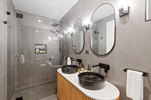 a bathroom with two sinks and a shower at Club Wyndham Airlie Beach in Airlie Beach
