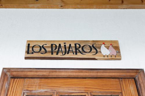 Una señal sobre una puerta con dos pollos. en Los Pajaros, en Santa Cruz de Tenerife