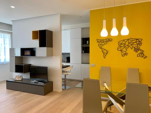 uma sala de jantar com uma parede amarela em Fifty Eight Milan Beltrade 3 em Milão