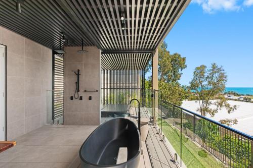 a bathroom with a black tub on a balcony at Club Wyndham Airlie Beach in Airlie Beach