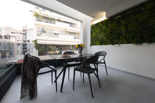 a dining room with a table and chairs on a balcony at Incanto Boutique Suites - Neos Kosmos in Athens