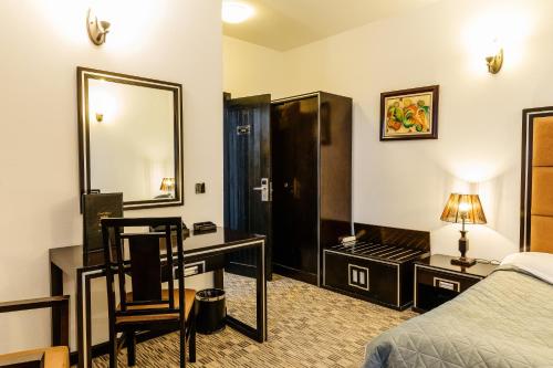 a hotel room with a bed and a desk and a mirror at CONTELE VLADIMIR in Bran