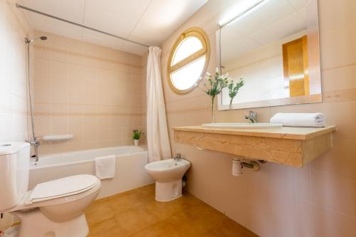 ein Badezimmer mit einem WC, einem Waschbecken und einem Spiegel in der Unterkunft Córdoba con bonitas vistas in Salou