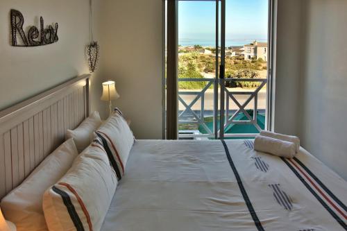 a bedroom with a bed with a view of the ocean at Birds View Holiday Home in Langebaan