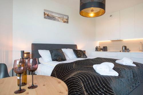 a bedroom with a bed and a table with wine glasses at Apartament Pobierowo PINEA in Pobierowo