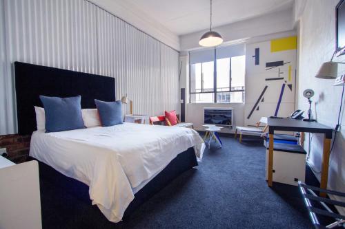 een slaapkamer met een bed en een woonkamer bij 12 Decades Art Hotel in Johannesburg