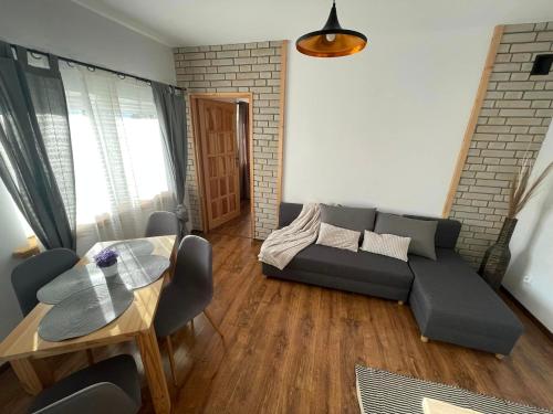 a living room with a couch and a table at Apartament Naglaka in Ząb