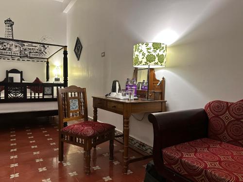 Zimmer mit einem Schreibtisch, einem Stuhl und einem Bett in der Unterkunft Villa Krish in Puducherry